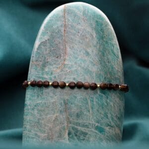 Ciemna damska bransoletka na czarnym sznurku z obsydianem i kuleczkami srebra pozłacanego zawieszona na kamieniu amazonit