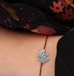 Srebrna bransoletka na jesień z liściem klonu na sznurku założona na ręce