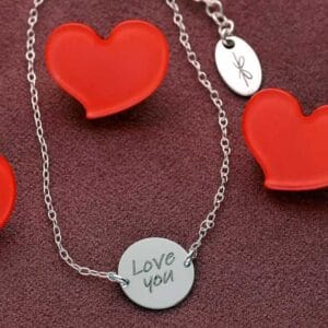 Srebrna bransoletka na łańcuszku ankier z celebrytką z napisem Love you. Bransoletka jest regulowana.