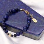 Bransoletka damska lapis lazuli srebrna pozłacana regulowana za pomocą przedłużki na łańcuszku. Bransoletka leżąca kawałku lapisu lazuli