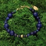 Bransoletka damska lapis lazuli srebrna pozłacana regulowana za pomocą przedłużki na łańcuszku. Bransoletka leżąca na mchu