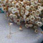 Damski naszyjnik srebrny rodowany z kwiatkiem ze srebra próby 925 wśród suszonych kwiatów