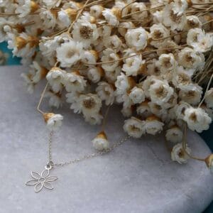 Damski naszyjnik srebrny rodowany z kwiatkiem ze srebra próby 925 wśród suszonych kwiatów
