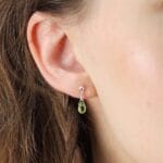 Damskie kolczyki wiszące z peridotem. Kolczyki srebrne pozłacane na sztyfcie założone na ucho