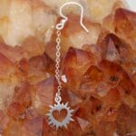 Kolczyki wiszące na łańcuszku długie z sercem w słońcu leżące na geodzie cytrynu. Idealne kolczyki bigiel otwarty na lato