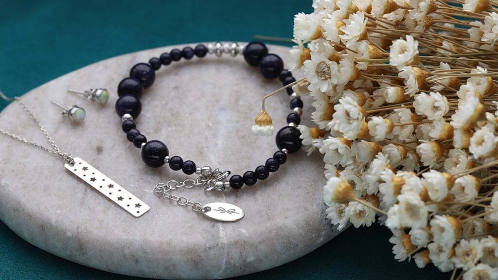 Biżuteria srebrna rodowana w formie kolczyków z opalem, naszyjnika srebrnego celebrytka i bransoletki damskiej z nocą kairu