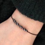 Damska bransoletka na sznureczku z hematytem na ręce