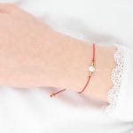 Elegancka i minimalistyczna bransoletka na czerwonym sznurku z perła i kuleczkami srebra pozłoconego