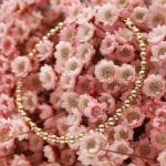 Damska bransoletka gold filled TWIN GOLD w kwiatach Damska bransoletka z kuleczek gold filled położona na kwiatach