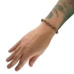 elegancka bransoletka męska elastyczna z kuleczek gold filled i brązowego fasetowanego agatu założona na ręke