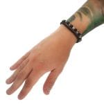 Elastyczna bransoletka męska z nakrapianego biało czarnego jaspisu i czarnego onyksu na ręce w towarzystwie podstawowej bransoletki męskiej z czarnego matowego onyksu