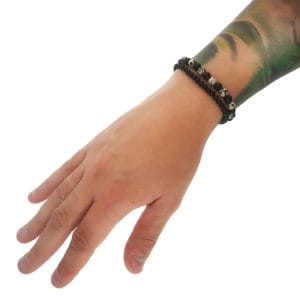 Elastyczna bransoletka męska z nakrapianego biało czarnego jaspisu i czarnego onyksu na ręce w towarzystwie podstawowej bransoletki męskiej z czarnego matowego onyksu