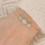 Bransoletka na beżowym sznureczku z zielonym pastelowym kamieniem amazonit na ręce