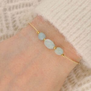 Bransoletka na beżowym sznureczku z zielonym pastelowym kamieniem amazonit na ręce