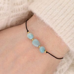 Bransoletka na czarnym sznureczku z zielonym pastelowym kamieniem amazonit na ręce