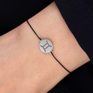 Damska bransoletka dla Bliźniąt na czarnym sznurku z celebrytką z grawerem znaku zodiaku Bliźnięta na ręce