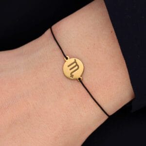 Bransoletka dla Skorpiona czarny sznurek z celebrytką. Bransoletka srebrna pozłacana na czarnym sznurku na ręce