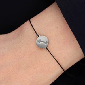 Bransoletka dla znaku zodiaku Strzelec na sznurku z celebrytką. Bransoletka srebrna na czarnym sznurku na ręce