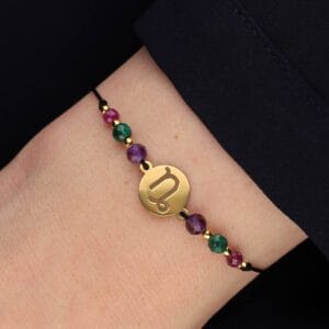 Bransoletka zodiakalna dla Koziorożca na sznurku z celebrytką i rubinem, malachitem i ametystem założona na ręce