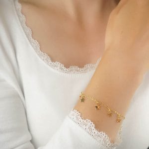 Damska bransoletka srebrna pozłacana z zawieszkami w kształcie gwiazdek. Bransoletka ubrana na ręke