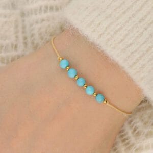 Damska bransoletka na beżowym sznureczku z niebieskim kamieniem turkus na ręce