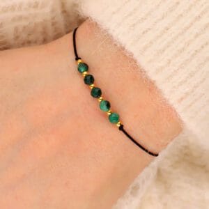 Damska bransoletka na sznureczku z zielonym kamieniem malachit na ręce
