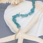 Złota bransoletka damska goldfilled z sieczką z apatytu i przedłużką zakończoną kuleczka położona na muszli