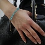 Ubrana na rękę trzymająca torebkę złota bransoletka damska goldfilled z sieczką z apatytu i przedłużką zakończoną kuleczka