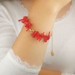 Damska pozłacana bransoletka z koralu RED CORAL na ręce Damska bransoletka srebrna pozłacana z słupkami korala czerwonego założona na rękę. Bransoletka posiada przedłużkę na której końcu zawieszona jest zawieszka z logo Rosett