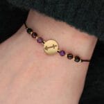 Damska bransoletka dla Strzelca na czarnym sznurku z celebrytką i ametystem,granatem i spinelem założona na ręce