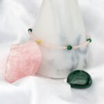 Bransoletka z kwarcem różowym i malachitem zawieszona na kamiennym słupku