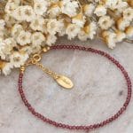 Damska bransoletka z bordowym granatem srebrna pozłacana przy kwiatach