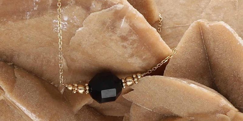 Elegancki i gustowny damski naszyjnik pozłacany z bryłką czarnego onyksu na róży pustyni