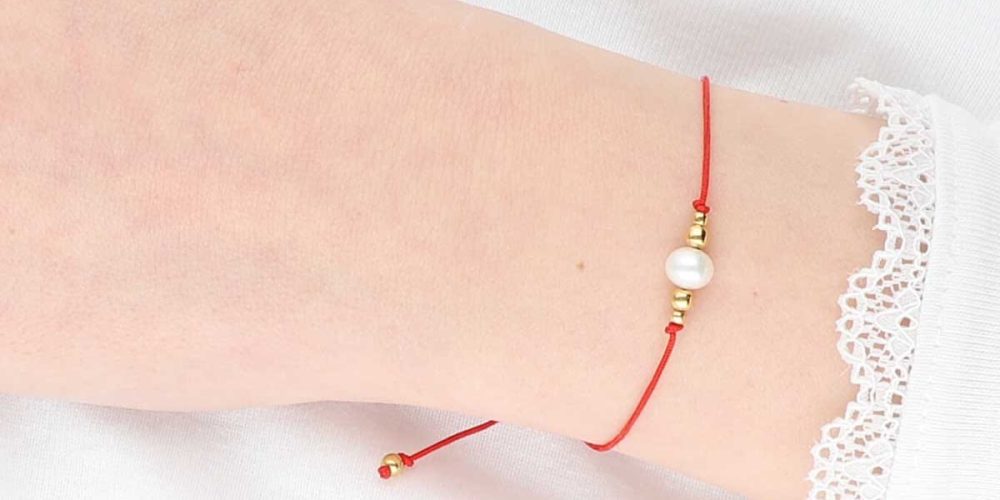 Elegancka i minimalistyczna bransoletka na czerwonym sznurku z perła i kuleczkami srebra pozłoconego