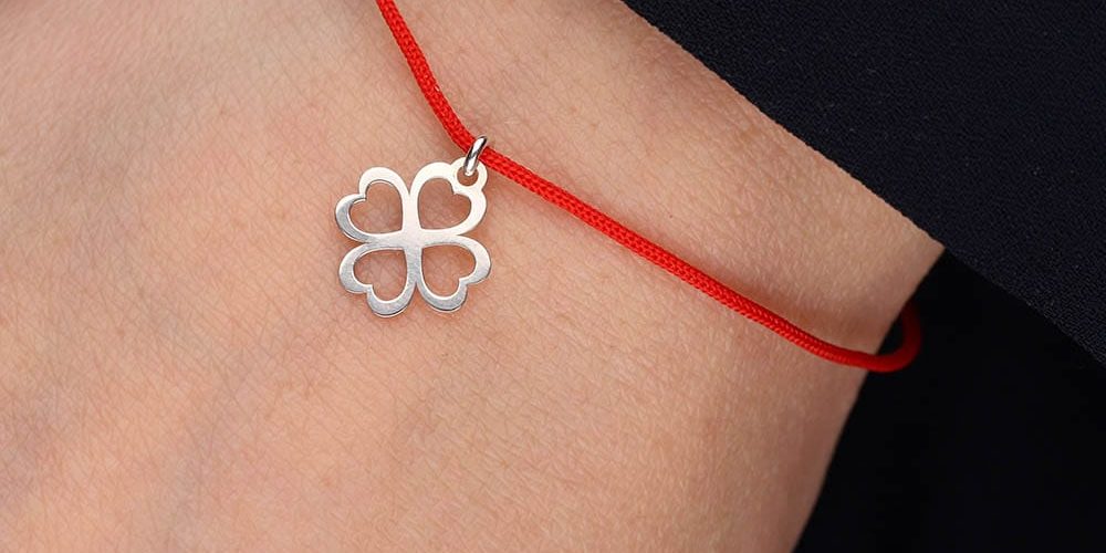 Bransoletka na szczęście srebrna z koniczynką na ręce