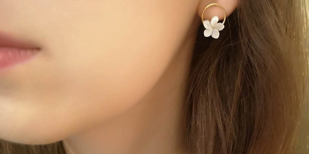 Stylowe kolczyki srebrne pozłacane na sztyftach z masą perłową w kształcie kwiatka założone