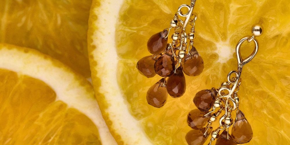 Kolczyki sztyfty srebrne pozłacane z wiszącymi kwarcami dymnymi leżące na cytrynach