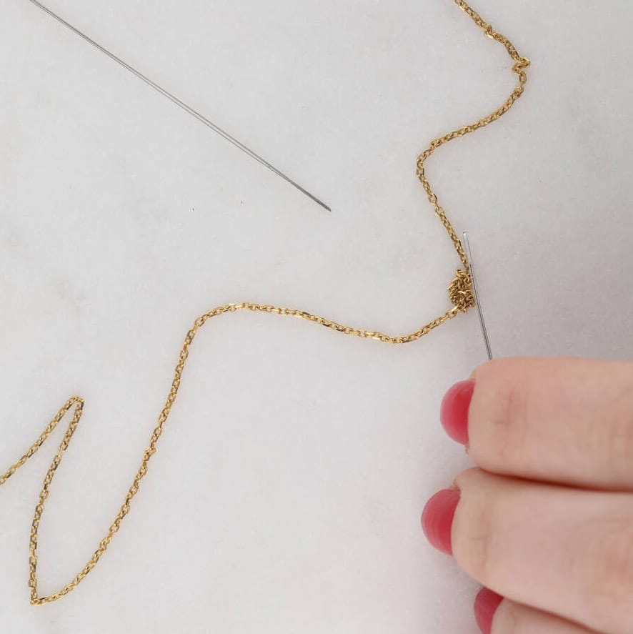 Rozplątanie łańcuszka domowym sposobem jest możliwe na przykład przy pomocy oleju i igiełek