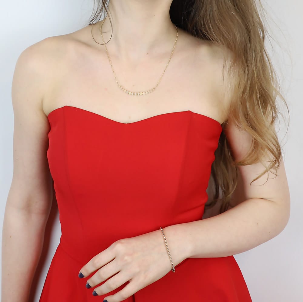 Minimalistyczna biżuteria doskonale pasuje do czerwonej sukienki - delikatna bransoletka w złotym kolorze oraz naszyjnik z opalami