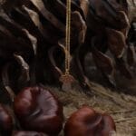 Jesienny naszyjnik z muchomorkiem. Grzybek pokryty cieniutka warstwą emalii która nadaje mu delikatny kolor. Całość wykonana ze srebra próby 925 pokrytego żółtym złotem. Naszyjnik wisi wśród szyszek i kasztanów