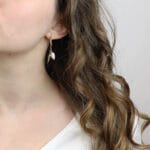 kolczyki na lato z muszelką i perłą założone na uchu