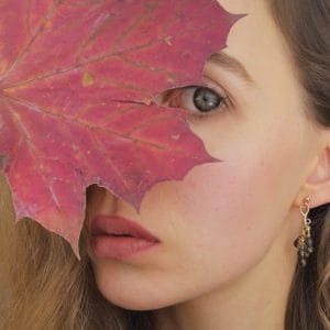 Kolczyki sztyfty srebrne pozłacane z wiszącymi kwarcami dymnymi założone na modelce