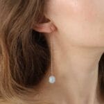 Damskie kolczyki długie wiszące z akwamarynem. Kolczyki srebrne pozłacane bigiel otwarty założone na ucho