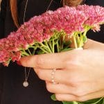 Stylizacja z długim damskim naszyjnikiem pozłacanym na różowo z zawieszoną kulką z kwarcu różowego oraz pierścionek elastyczny z kwarcu różowego i kuleczek srebrna