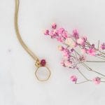 Kobiecy naszyjnik srebrny pozłacany z kamieniem księżycowym rubinem przy kwiatku