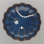 Stylowa i elegancka biżuteria damska w formie bransoletki, kolczyka i naszyjnika. Naszyjnik i bransoletka z naturalnymi perłami, kolczyki na sztyfcie z masą perłową w kształcie kwiatka