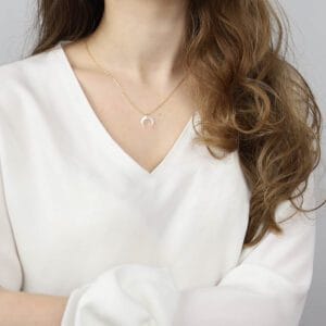 naszyjnik z masą perłową w kształcie rogu obfitości w splocie ankier ubrany na szyi