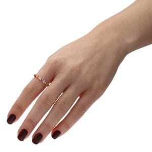 Kolorowy pierścionek elastyczny z cyrkoniami i kuleczkami gold filled założony na palcu