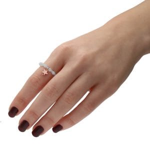 delikatny pierścionek pozłacany elastyczny z akwamarynem i gwiazdką z hematytu FROZEN założony na palec