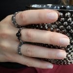 Zestaw pięknych ciemnych pierścionków elastycznych z onyksu, spinela i hematytu założone na palce